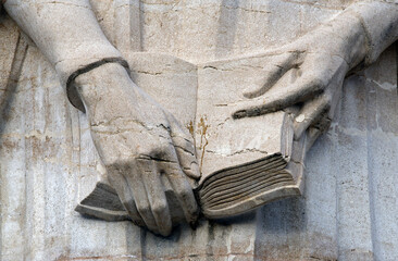 Jean Calvin Statue, close-up of his hands holding the bible, engraved in stone, Reformation Wall in...