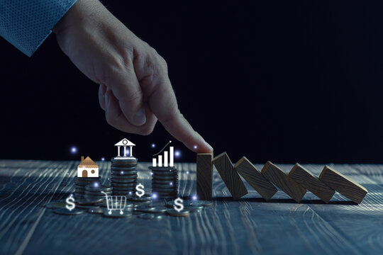 Economic collapse concept, hands stop domino crisis effect, financial and banking problems, recession, financial crisis, bad debt, inflation and interest rates,  asset safety