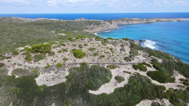 Aerial view of mountain bikes touring around edge of Menorca on summers day.