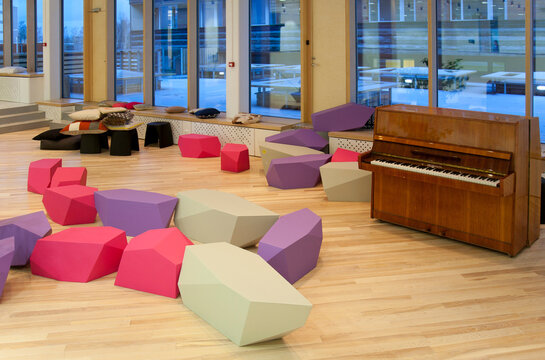 An education building, healthcare college, an open atrium area with piano and seating.