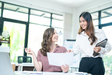 Smiling businesswoman working together on contract document, happy colleague meeting for planning new project in office