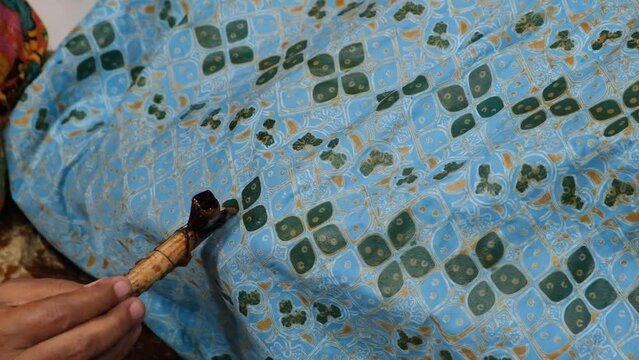 The process of making hand-written batik on a cloth with heated wax, typical of Surakarta in Indonesia
