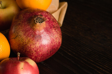 Fruit in a reusable bag. Earth day and zero waste concept. Apple, orange and pomegranate close-up on a dark background