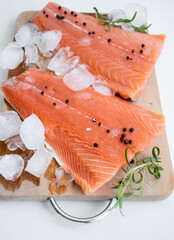 raw salmon fillet on a wooden cutting board. On a white background.