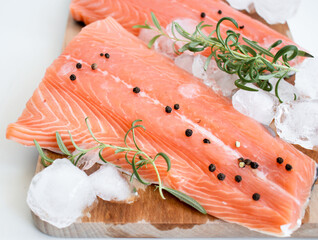 raw salmon fillet on a wooden cutting board. On a white background.
