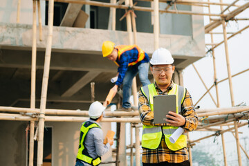 Architect caucasian man working with colleagues mixed race in the construction site. Architecture engineering on big project. Building in construction interior.