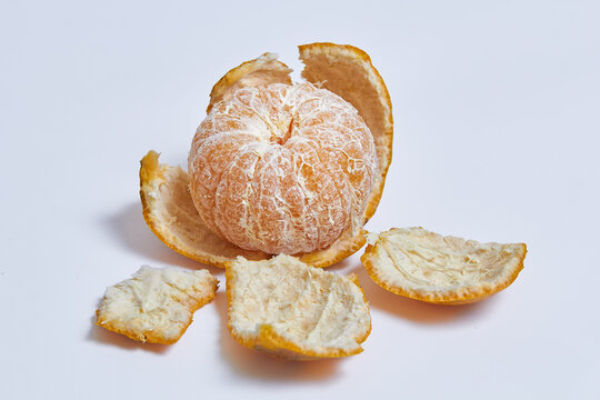 Peeled Orange with outer layer of skin removed, leaving the juicy and colorful flesh inside exposed on isolated white background
