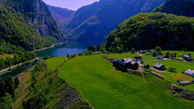 Aerial drone forward moving shot of town houses in alongside a fjord in Lofoten islands, Norway on a sunny day.