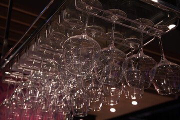 Hanging glasses over the bar, many clean glasses