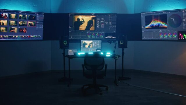 Studio with modern equipment for color correction. Computer, digital tablet and big screens showing color grading program interface with movie footage, RGB graphics and color wheels. Post production.