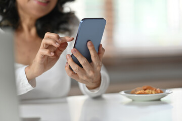 Close up view of senior woman typing massage on her mobile phone. Technology, communicating concept