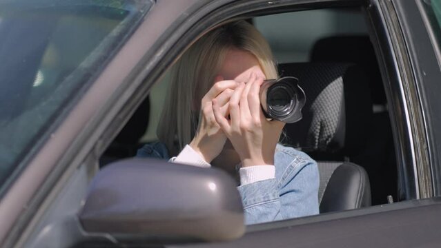 Hidden photographing. Paparazzi Concep Photographer uses his professional camera. Photographer girl in car window. Mobile reporter. Photojournalist at work. Detective or investigator.