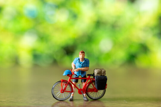 Miniature people standing with bike and green background , World bicycle day concept