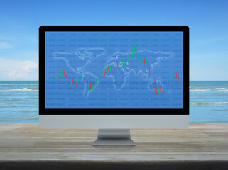 Trading graph of stock market with world map and graph on computer screen on wooden table over tropical sea and blue sky, Business investment online concept, Elements of this image furnished by NASA