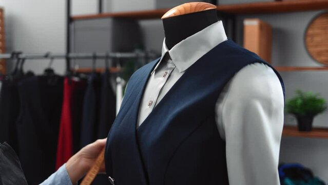 Female dressmaker hands checking size fashion classic clothes with shirt and vest use tape measure