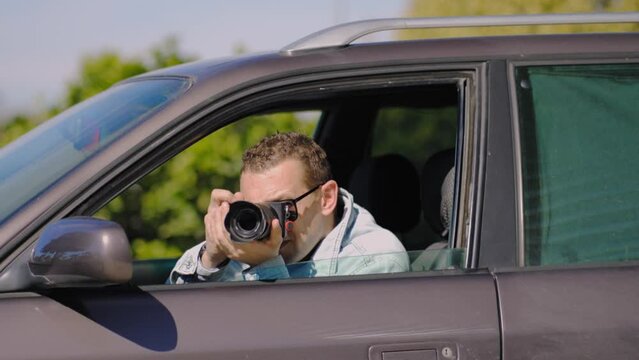 Hidden photographing. Paparazzi Concep Photographer uses his professional camera. Private detective man in car window. Mobile reporter. Photojournalist at work. Detective or investigator.