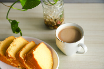 pieces of sponge cake or kue bolu served on a plate with a glass of coffee