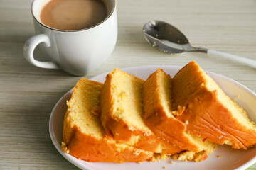 pieces of sponge cake or kue bolu served on a plate with a glass of coffee