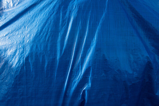 A blue tarpaulin covering a hidden object.