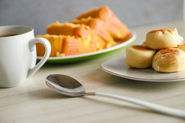 pieces of sponge cake or kue bolu served on a plate with a glass of coffee