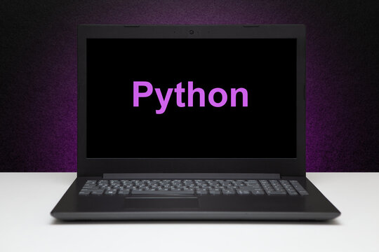 Python text on laptop screen on textured black background with purple light. Learn swift programming language, computer courses, training.