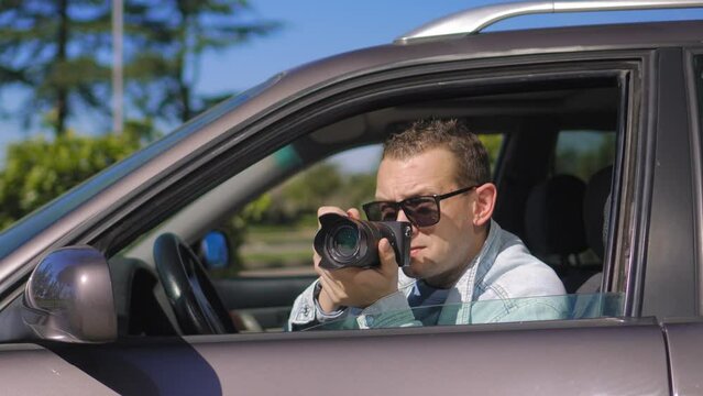 Hidden photographing. Paparazzi Concep Photographer uses his professional camera. Private detective man in car window. Mobile reporter. Photojournalist at work. Detective or investigator.