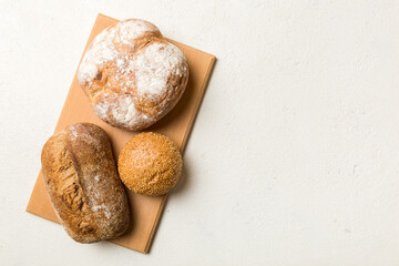 Freshly baked bread on cutting board against white wooden background. top view bread with copy space