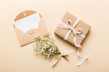 Wedding mockup with white paper list and flowers gypsophila on colored table top view flat lay....