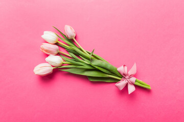 Bouquet of pink tulips on colored table background . Top view with copy space. Waiting for spring. Happy Easter card. Flat lay