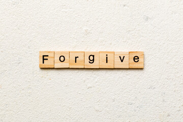 Forgive word written on wood block. Forgive text on cement table for your desing, Top view concept