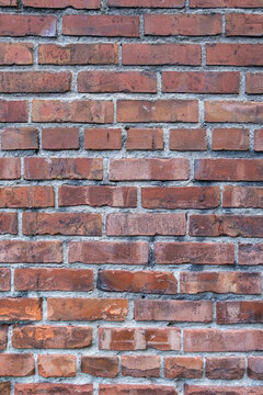 Fototapeta A brick wall, red clay bricks laid in a regular pattern to make a wall.