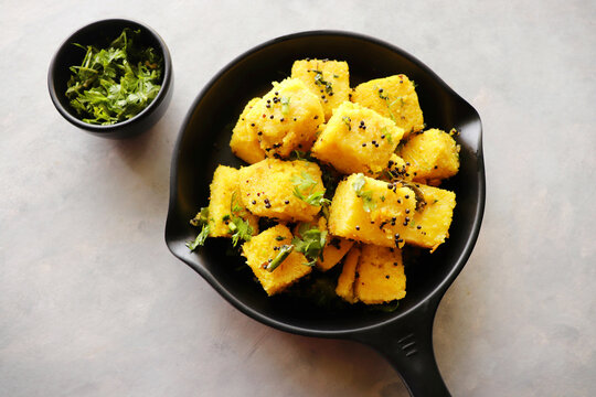 Indian chana Dal dhokla. Khaman dhokla is a famous dish of Gujarat. Made using rice, a healthy mix lentils and pulses, along with spices. garnished with coriander and fried chilies. Copy space
