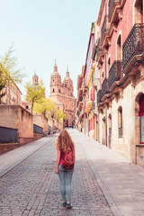 Woman walking in the street of Salamanca with cathedral view in the background- Spain - obrazy, fototapety, plakaty