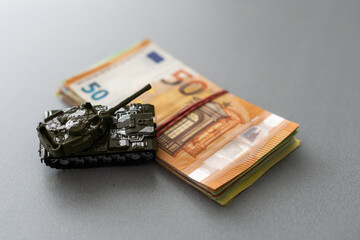 Economic crisis concept. Toy military tank on euro banknotes. War conflict in Ukraine, economic...