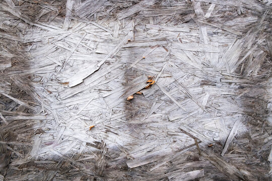 Old white paint on particle board, chipboard, close up.