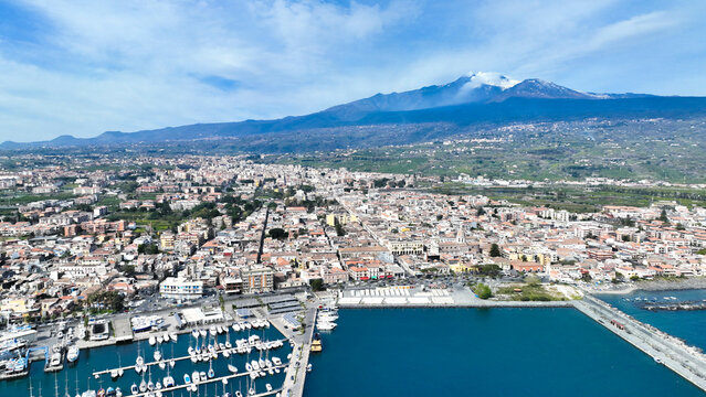 Riposto - panoramica aerea dall'alto sul porto della citt&agrave; durante giornata di sole con Etna sullo sfondo