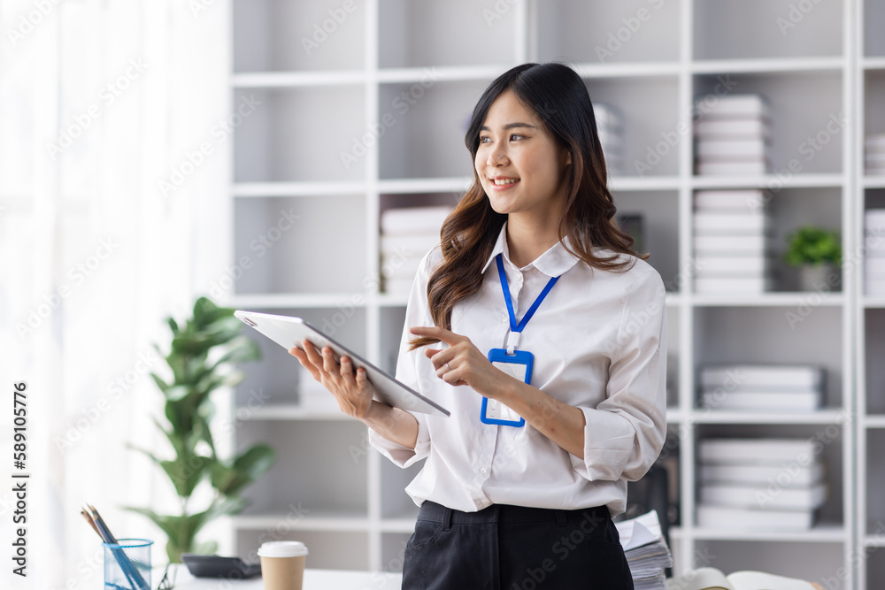 Wall mural Young business Asian woman employee holding document file accounting checking financial data and stand in workplace office Paperwork management.
