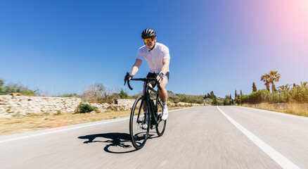 Man Adult on a racing bike climbing the hill at mediterranean sea landscape coastal road on...