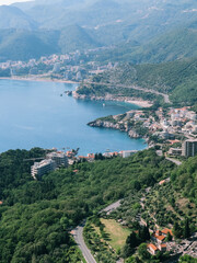 Modern high-rise buildings on the coast of the Bay of Kotor among green trees