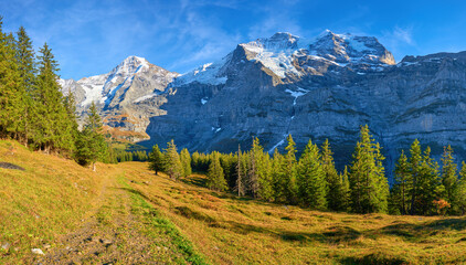 Naklejka premium Mountains panorama view of Monch and Jungfrau peaks from hiking trail near Wengen alpine village in Switzerland.
