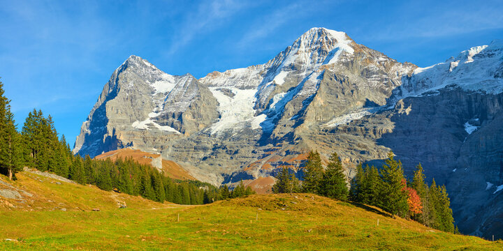 Impressive mountains panoramic view of Eiger and Monch peaks from hiking trail near Wengen alpine village in Switzerland.