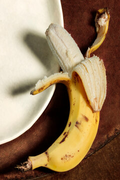 Peeled banana on a wooden table