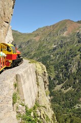 Obraz premium Train passing a vast mountainous landscape in the countryside