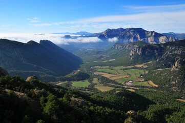 Fototapeta na wymiar Beautiful view of the rocky mountain range and green valley with dense vegetation.