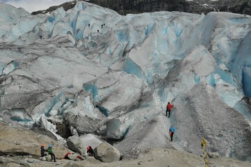 Group of people climbing up a mountain on a glacier