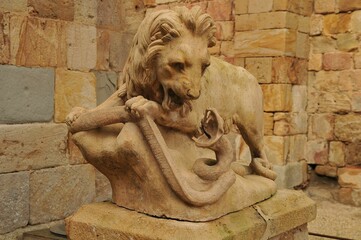 Old statue of lion fighting with snake at the Fontfroide Abbey, Languedoc-Roussillon, France