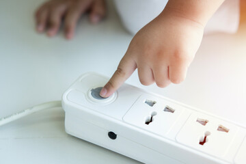 Toddler is playing with a power outlet. Danger of electric shock at home.  Child Plugs in Electrical Socket.