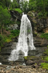 Fototapeta na wymiar Vertical shot of Steinsdalsfossen, a waterfall in the village of Steine, Kvam, Vestland, Norway.