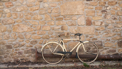 Bici antigua apoyada en pared de piedra