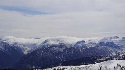 Wolken kriechen über beschneiten Berg 